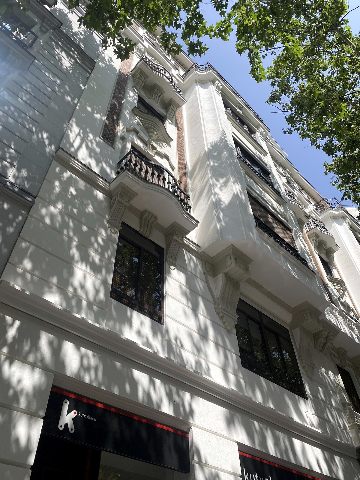 Detalle de balcón restaurado con balaustrada de hierro forjado en edificio protegido